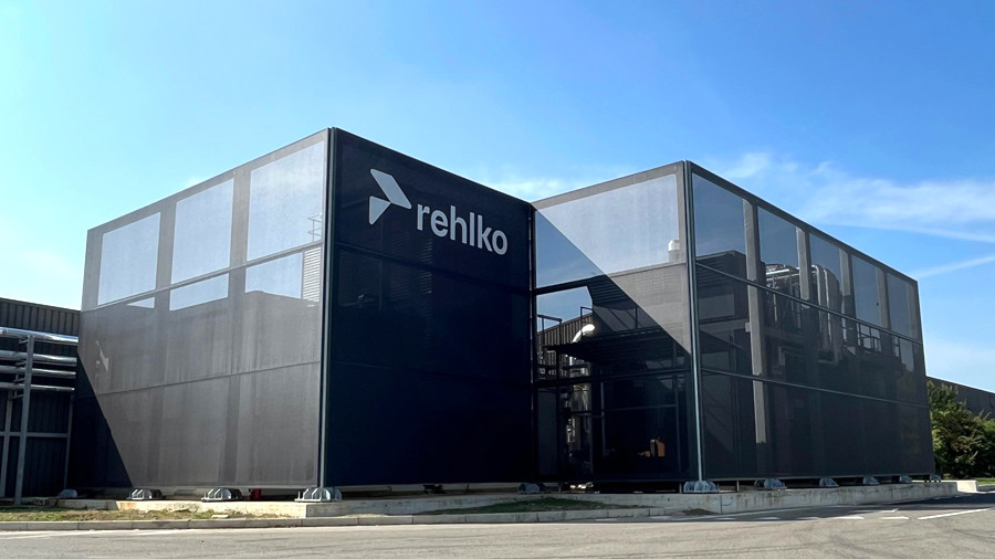 Facciata tessile in rete antracite su edificio industriale